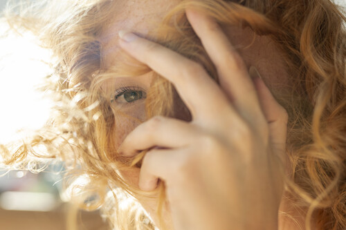 Close up woman covering her face